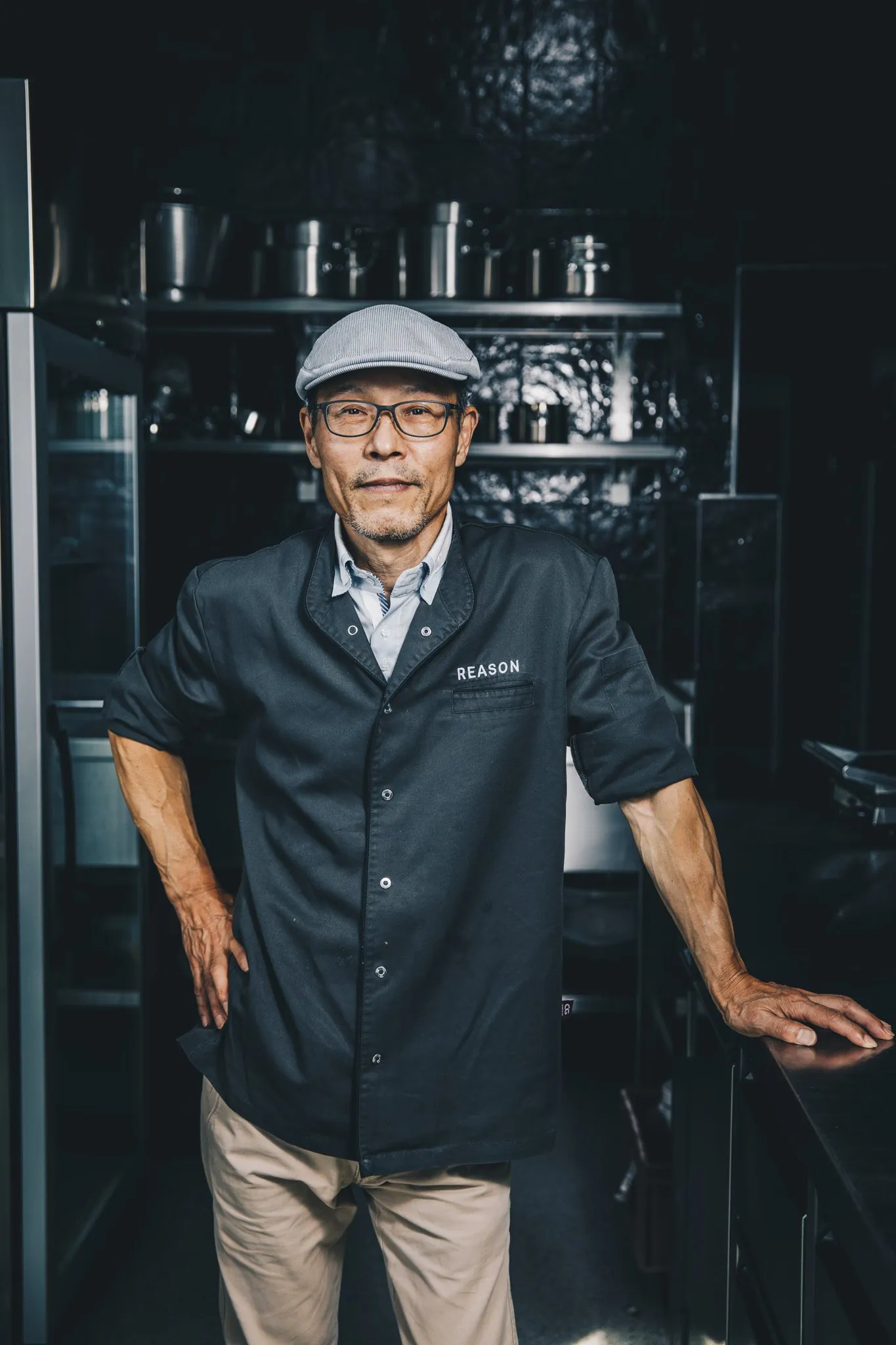 Koch in Arbeitskleidung in der dunklen Restaurantküche, Portrait on Location