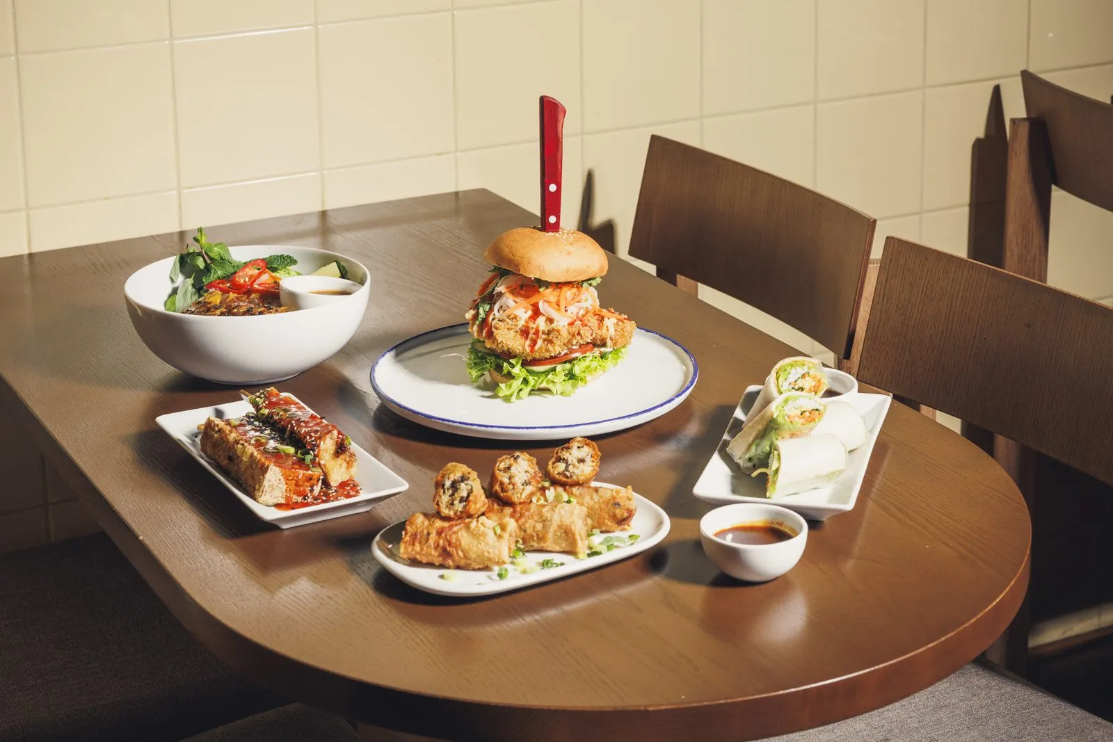 Tisch mit Burger, Bao und asiatischen Vorspeisen im Restaurant CONG