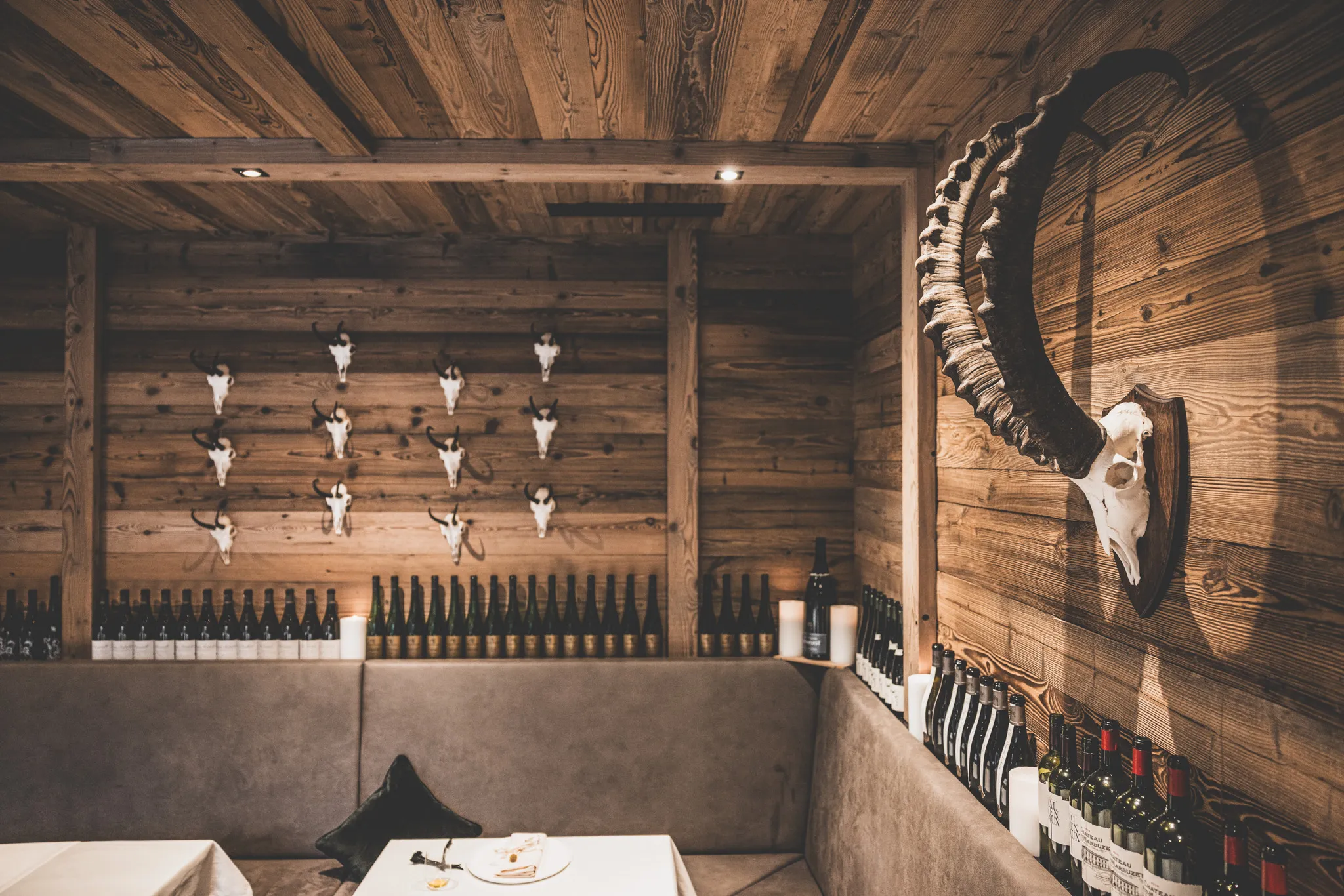 Gaststube aus Altholz mit Steinbockgehörn, Schädeln an der Wand und Weinregal