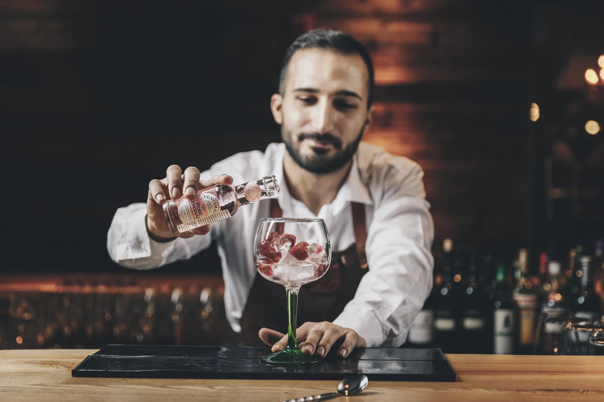 Barkeeper garniert einen Gin Tonic an der Bar