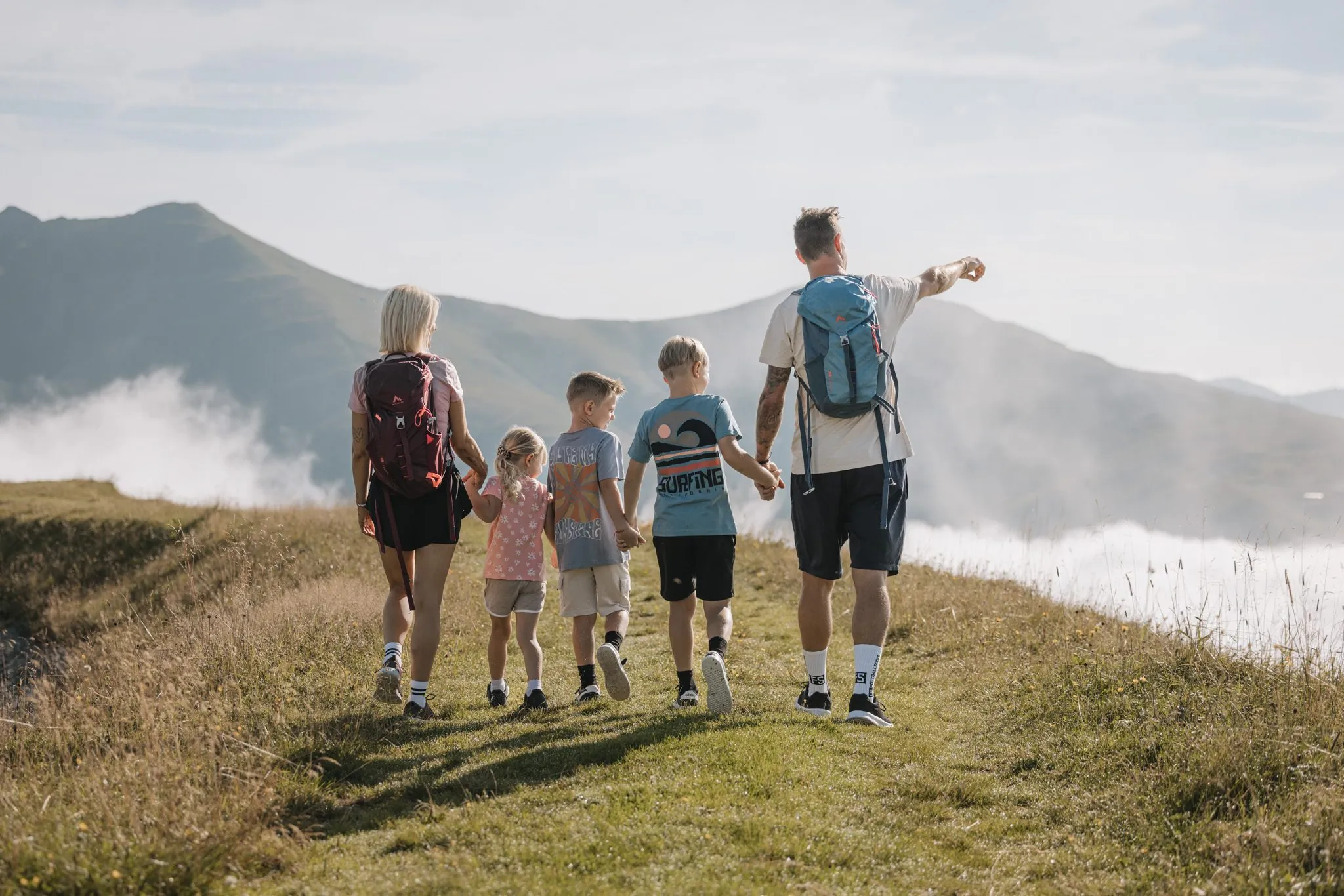 Familie wandert über eine Almwiese mit Blick auf die Zillertaler Alpen, Hotel Gaspingerhof